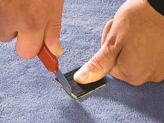 Teppich reparieren: Reparaturstueck mit Cutter-Messer ausschneiden